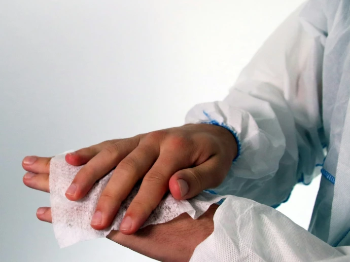 person in white long sleeve shirt holding white tissue paper